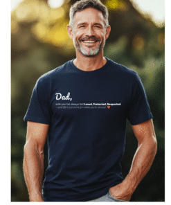 A smiling middle-aged man wearing a dark navy blue t-shirt showing a Dad text design on the front