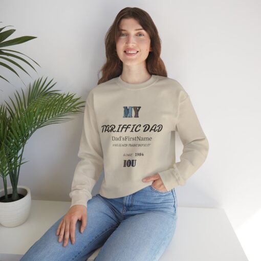 A smiling girl sitting on a couch in her living room wearing a sand color t-shirt showing a My Dad message on the front